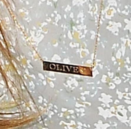 Drew Barrymore's gold nameplate necklace dedicated to her daughter Olive