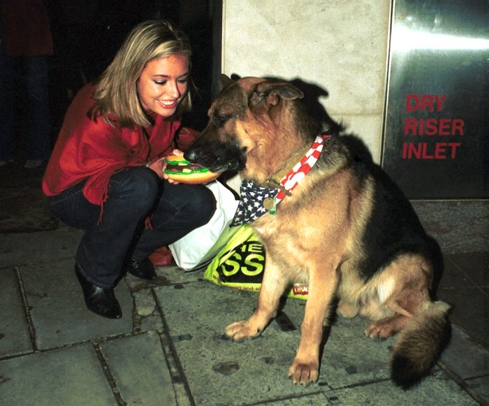 Cat Deeley meets the famous German shepherd Oscar the Met Bar dog on May 26, 1998, in London, England