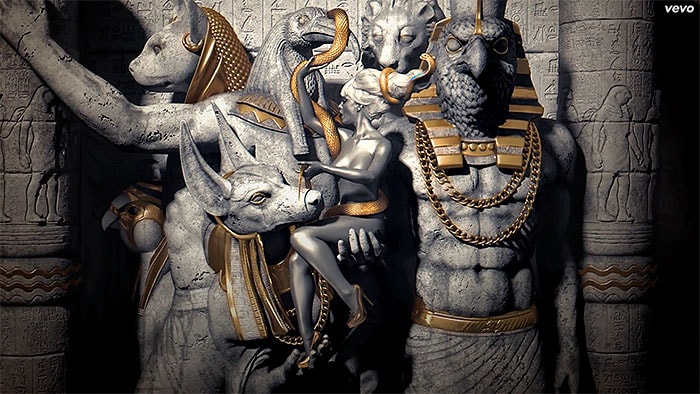 Katy Perry, transformed into a silver Egyptian goddess, pairs gold mirror pumps with stunning statues of deities