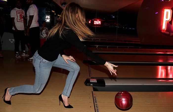 Khloé Kardashian bowls in a black sweater, tight jeans and stiletto heels