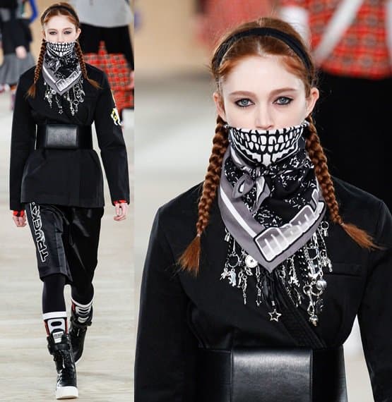 A model struts the Marc by Marc Jacobs Fall 2014 runway at New York Fashion Week, donning a striking black outfit accented with a skull-print bandana, braided hair, and bold accessories