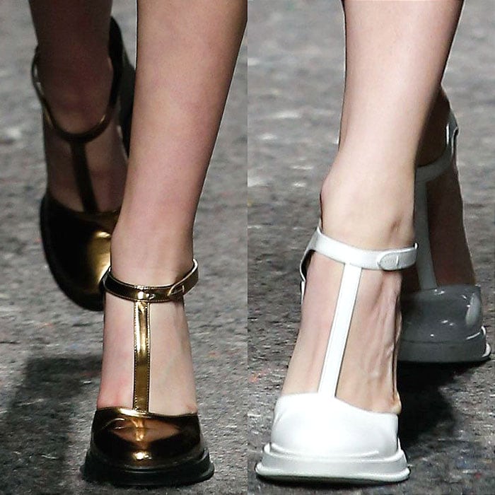 Prada's refined T-strap pumps with glossy metallic and matte finishes featuring bold gold and crisp white designs
