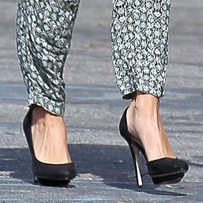 Selena Gomez showcases her chic style in black Zara platform heels, effortlessly elevating her laidback floral jumpsuit with a touch of timeless sophistication