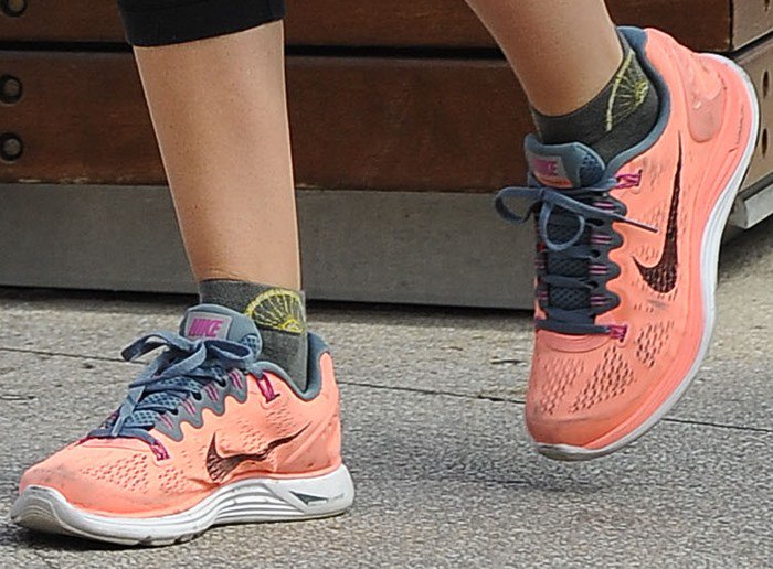 Ashley Tisdale's feet in coral-colored Nike sneakers