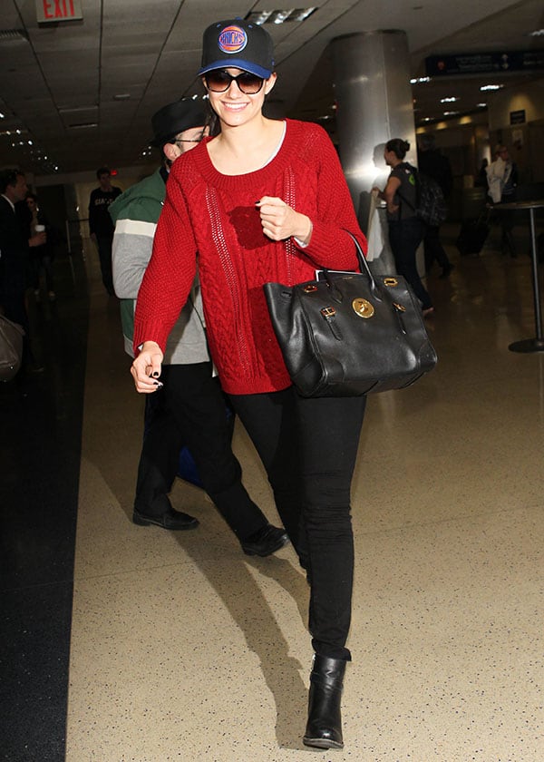 Emmy Rossum at LAX Airport on March 16, 2014, wearing a Lovers + Friends so good sweater, black jeans, black boots, and carrying a Ralph Lauren Ricky bag