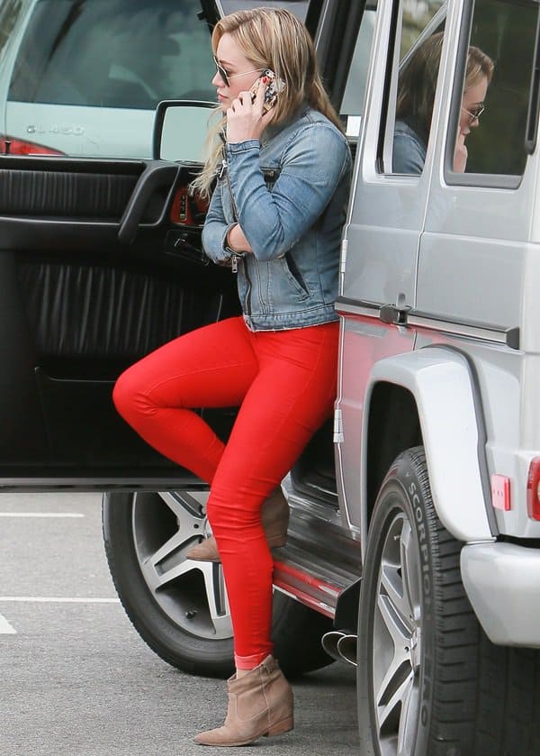 Hilary Duff pairs bold red skinny jeans with beige Belle by Sigerson Morrison wedge ankle boots for a casual yet eye-catching look on March 22, 2014
