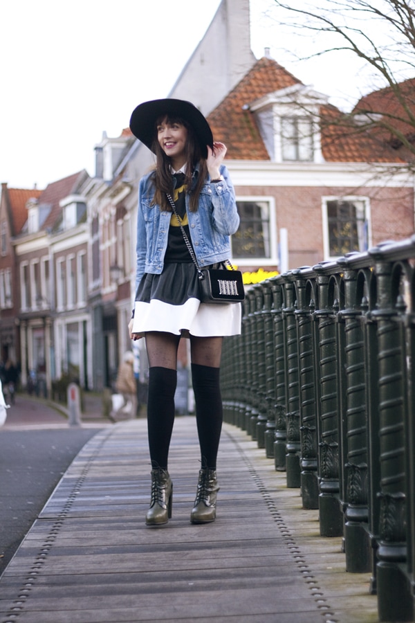 Iris wears a graphic-printed tee and a high-waisted skirt with a denim jacket