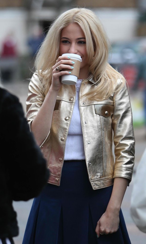 Embodying golden glamour, Pixie Lott captivates in a metallic gold leather jacket, elevating her look with a touch of shimmer that reflects her star quality and fashion-forward mindset