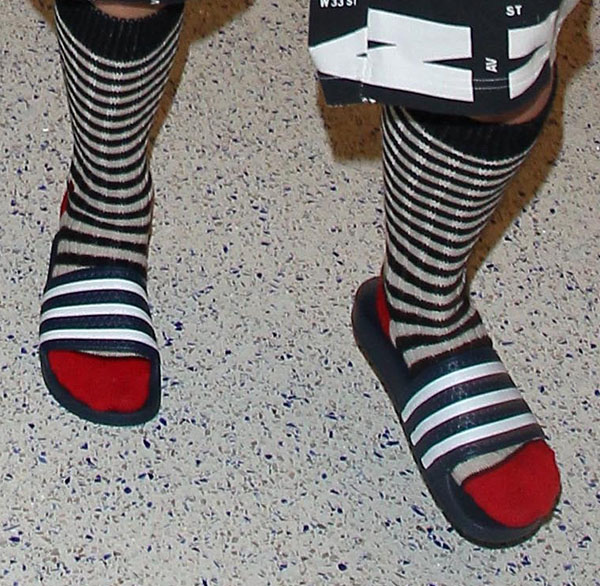 Rita Ora wearing adidas "Adilette" pool slide sandals with striped red-toed socks