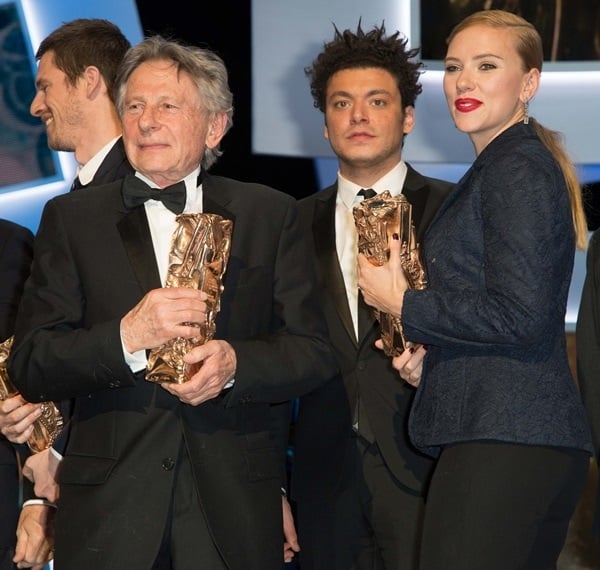 Roman Polanski holds the Best Director award for 'Venus in Fur' while actress Scarlett Johansson holds the Honorary Cesar award on stage during the 39th Cesar Film Awards 2014