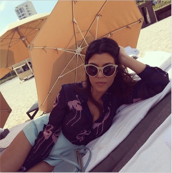 Kourtney Kardashian’s Instagram photo captioned ‘Beach life. #miami,’ posted on March 13, 2014, showing her lounging in a flamingo-printed Noon by Noor blouse and baby blue shorts while soaking up the sun in Miami