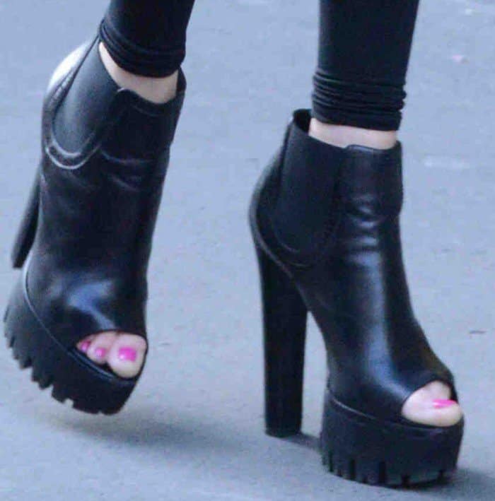 Allegra Versace's feet in chunky black leather booties