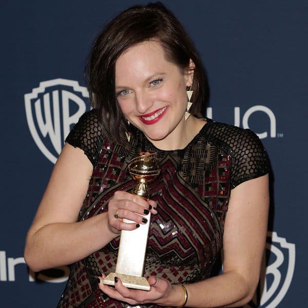 Elisabeth Moss with chin-length hair tucked behind one ear