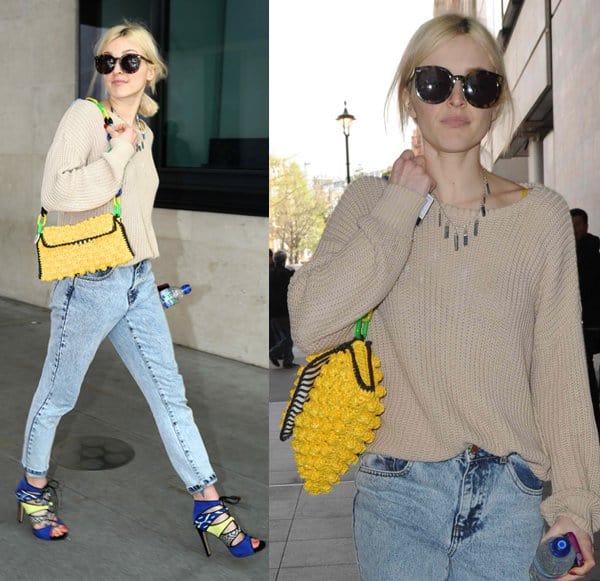 Fearne Cotton effortlessly combines a cozy nude knit top with stylish faded boyfriend jeans, eye-catching lace-up sandals, and a bright yellow chain-strapped purse for a chic and casual look