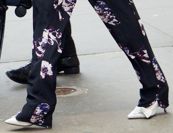 A closer look at Lindsay Lohan’s Isabel Marant “Poppy” pumps, featuring stitched bows and a sleek white snakeskin finish peeking out beneath her floral trousers
