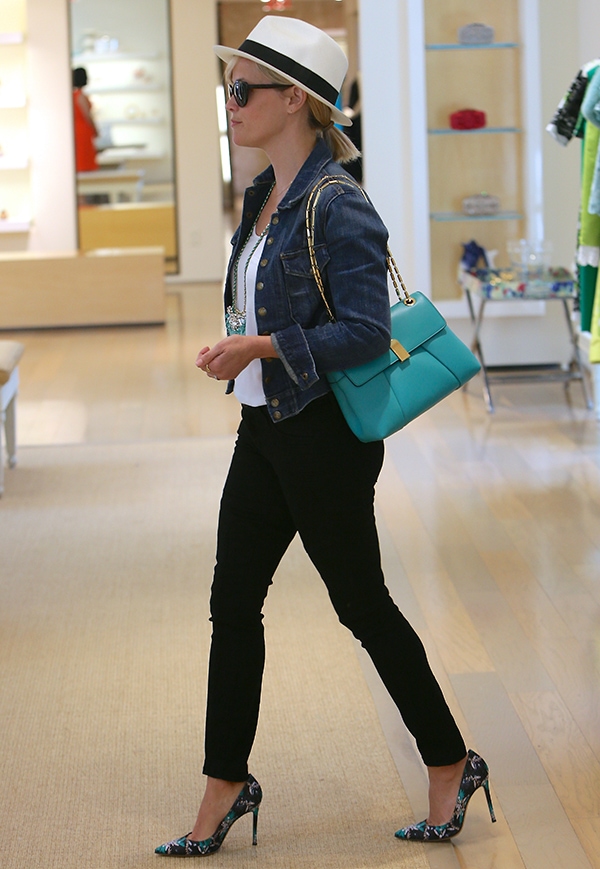 Reese Witherspoon stuns in effortless spring chic, pairing her Mary Katrantzou x Gianvito Rossi floral pumps with a denim jacket, turquoise bag, and fedora while shopping at Oscar de la Renta in Los Angeles on April 16, 2014