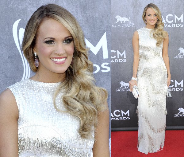 Carrie Underwood glows at the 49th Annual Academy of Country Music Awards in a fringed white Oscar de la Renta gown, perfectly complemented by her voluminous waves, soft pink lipstick, and sparkling drop earrings