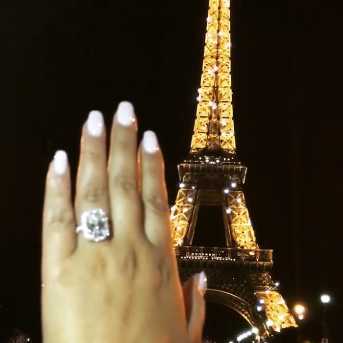 Adrienne Bailon's engagement ring features colorless an 8-carat emerald-cut diamond embraced by a halo of French-pave set diamonds set in platinum