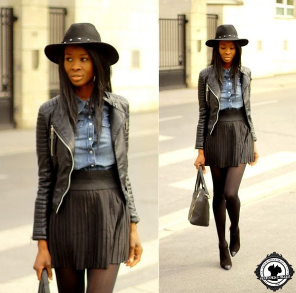 Assitan wears an embroidered shirt tucked into a pleated leather skirt