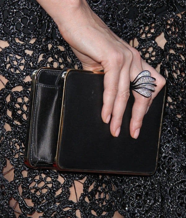 Charlize Theron toted a black Roger Vivier clutch and accessorized with Cartier jewelry