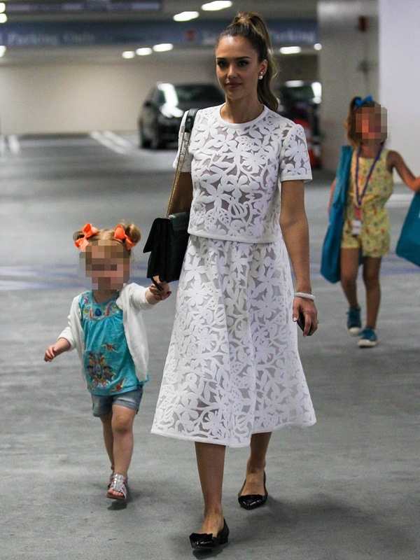 Jessica Alba wears a white floral dress and flat shoes and holding hands with daughter Haven Warren as she takes her children to the Hammer Museum of Art