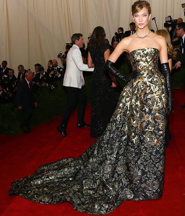 Karlie Kloss exudes elegance in an Oscar de la Renta fall 2014 strapless gown with intricate gold embroidery at the 2014 Met Gala