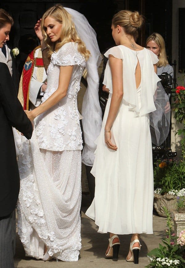 Poppy Delevingne and her sister Cara Delevingne, who served as Maid of Honor, share a moment at Poppy's wedding, both elegantly dressed in Chanel