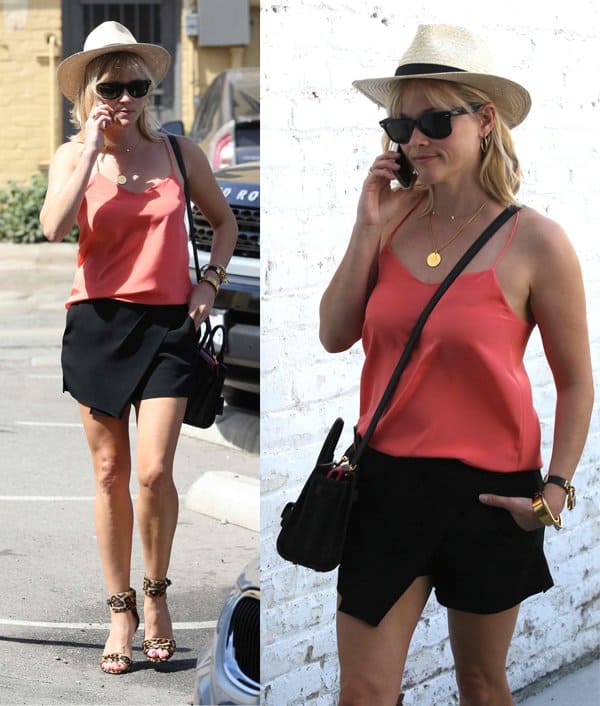 Reese Witherspoon, wearing leopard-print high heels, arrives by the back door at the Rossano Ferretti Hairspa, in a straw hat while talking on her cell phone in Los Angeles on May 1, 2014