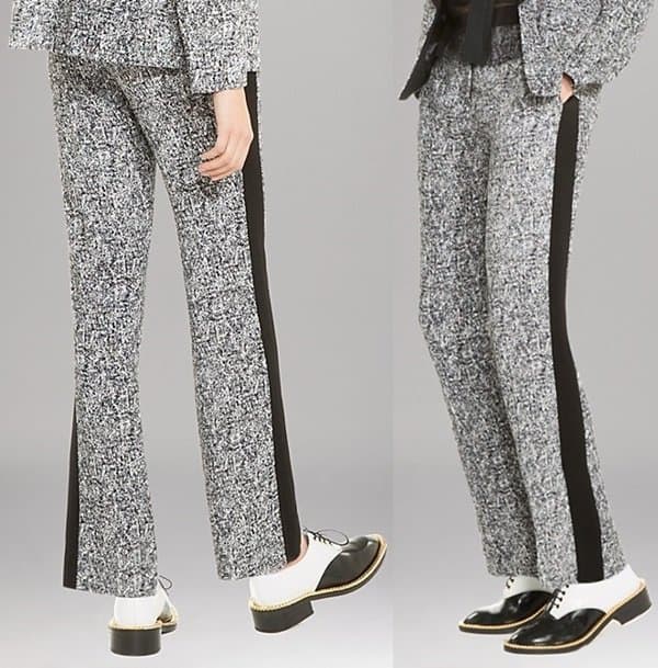 The Sandro Paris pants feature an allover confetti-like print, contrasting black tuxedo stripes along the sides, a zip fly with hook closure, a solid waistband, and two front slit pockets