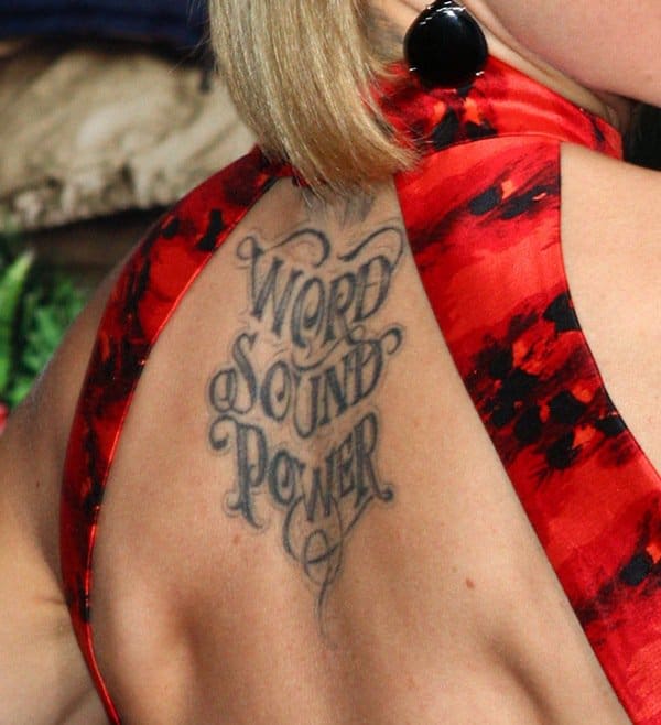 Mena Suvari displays her "Word Sound Power" tattoo on her upper back in a striking red dress