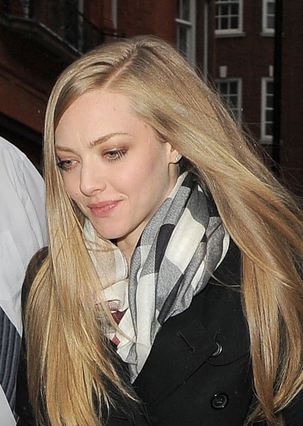 Amanda Seyfried looks elegant in a black trench coat and checkered scarf while out in London
