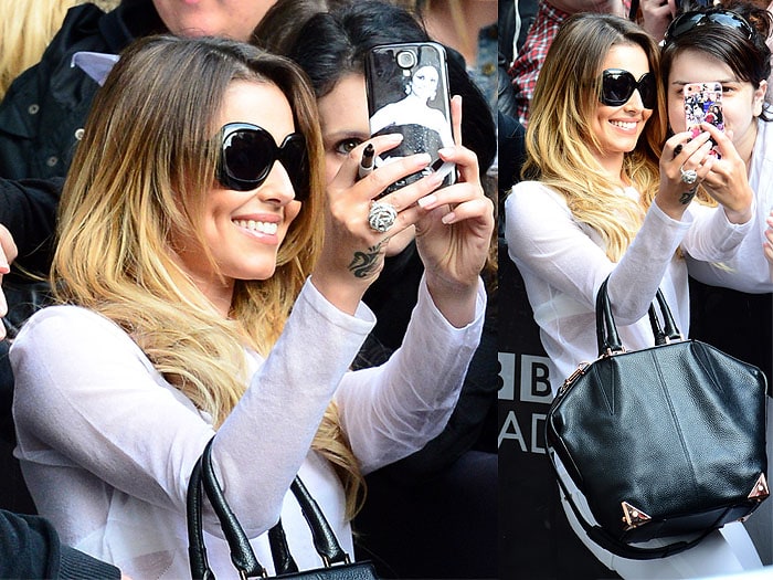 Cheryl Cole taking selfies with fans outside the BBC Radio 1 studios in London