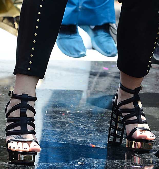 Demi Lovato showcasing her edgy style in bold Gianmarco Lorenzi strappy sandals with metallic accents and statement cage heels