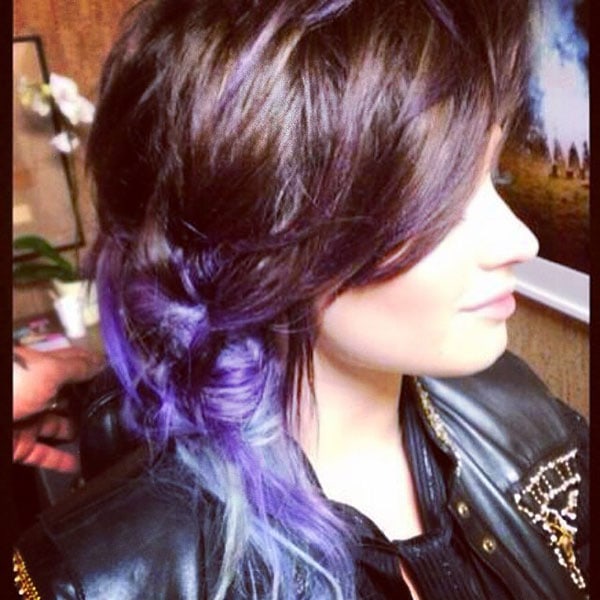 Demi Lovato rocks a stylish side braid showcasing her vibrant lavender and silver ombre hair