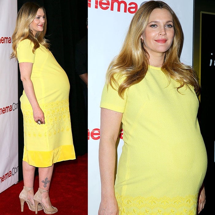 We see Drew Barrymore tried hard to smize with a huge nine-month baby bump while wearing high heels