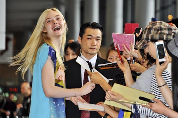 Elle Fanning signing autographs for a large group of fans at Narita International Airport in Japan