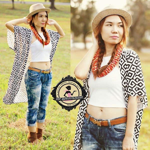 Julie styled a chic necklace with distressed boyfriend jeans, a printed cape, and a fedora