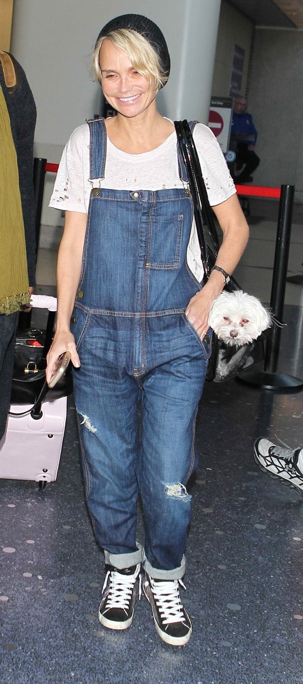 Kristin Chenoweth keeps it casual and cool in ripped denim overalls, paired with a beanie and high-top sneakers at LAX