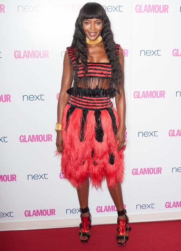 Naomi Campbell stuns in a dramatic red and black feathered Alexander McQueen dress paired with gladiator sandals at the 2014 Glamour Women of the Year Awards