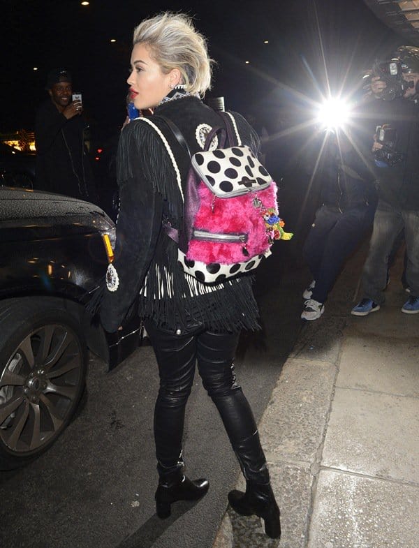 Rita Ora rocked an edgy all-black fringe outfit and platform ankle boots, adding a playful twist with a fuzzy pink polka-dot backpack outside Novikov restaurant in Mayfair