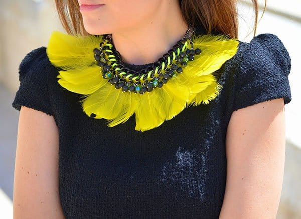 Patricia's vivid yellow feather necklace featuring iridescent green crystals and black stones