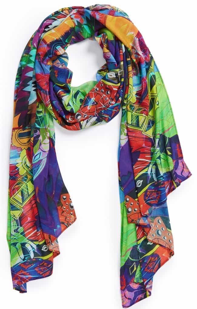 A gauzy scarf is sure to turn heads with a color-saturated print that provides a stunning visualization of multicultural traditions of celebration, spirituality and dance