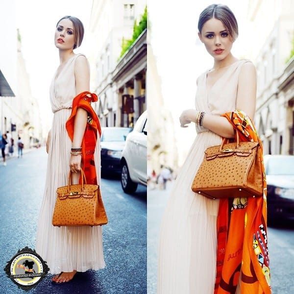 Kristina Bazan of Kayture decorates her dress by wearing a bright scarf and handbag at the crook of her arm