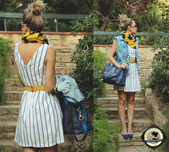 Priscila B. of My Showroom Blog styles her striped dress by wrapping a poppy printed yellow scarf around her neck