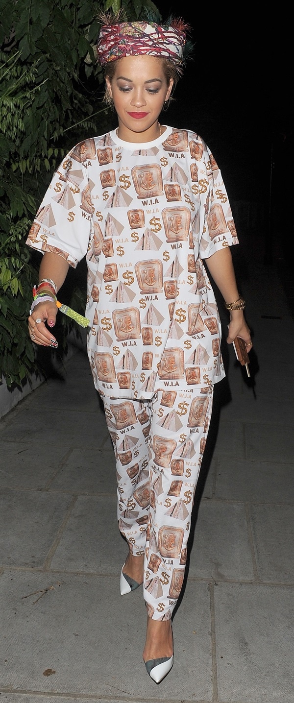 Rita Ora rocks a quirky baggy W.I.A. Collections outfit with Egyptian-themed prints, paired with chic Christian Louboutin "Miss Rigidaine" pumps and a feathered headscarf