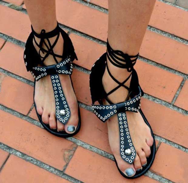 Isabella shows off her pedicured feet in flat black sandals with grommets