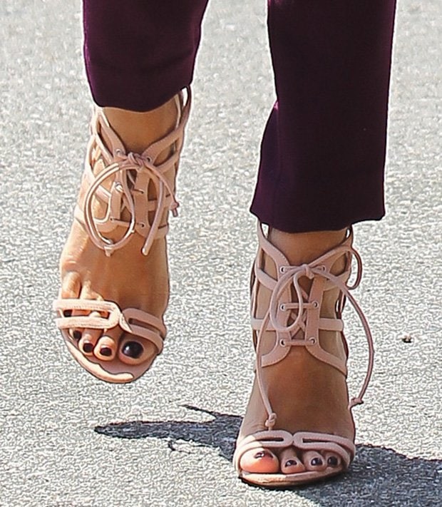 Jessica Alba shows off her chic pedicure in nude lace-up sandals, perfectly complementing her polished look with dark, glossy toenails adding a touch of contrast
