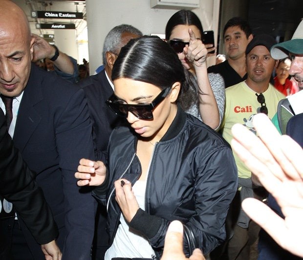 Kim Kardashian and her younger sister Kendall Jenner are mobbed by paparazzi photographers and members of the media
