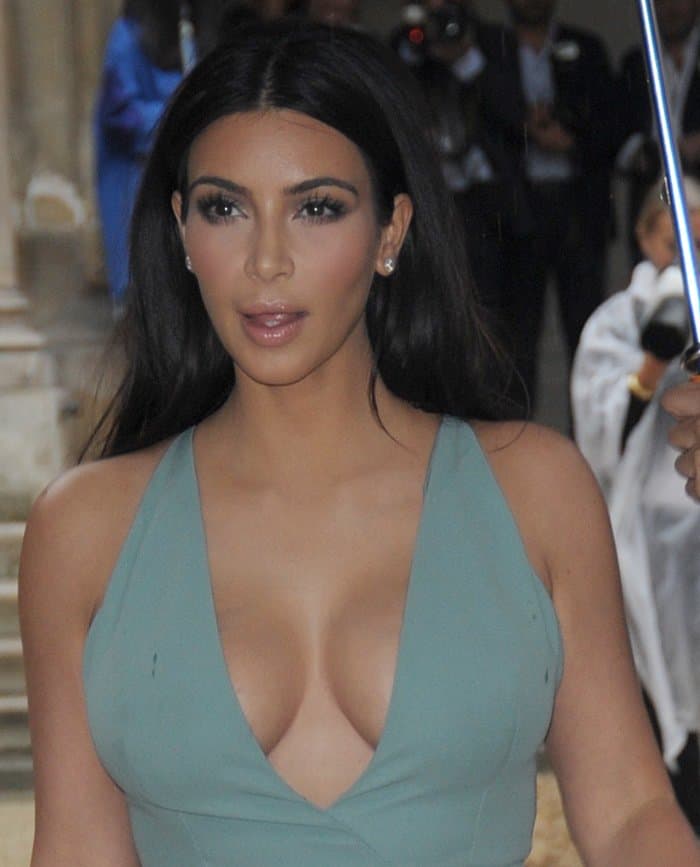 Kim Kardashian maintained her signature style by appearing in a powder turquoise, low-cut halterneck gown at the Paris Fashion Week Haute Couture Fall/Winter 2014–2015 (Valentino show) in Paris