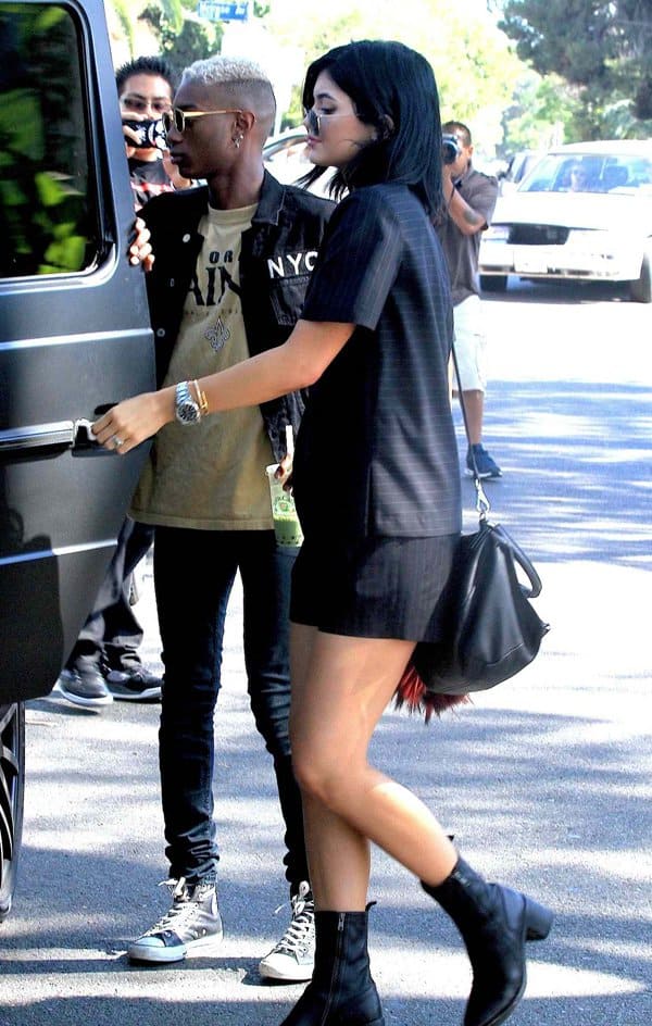 Kylie Jenner pairs her monochrome pinstriped ensemble with sleek black boots and a minimalist handbag